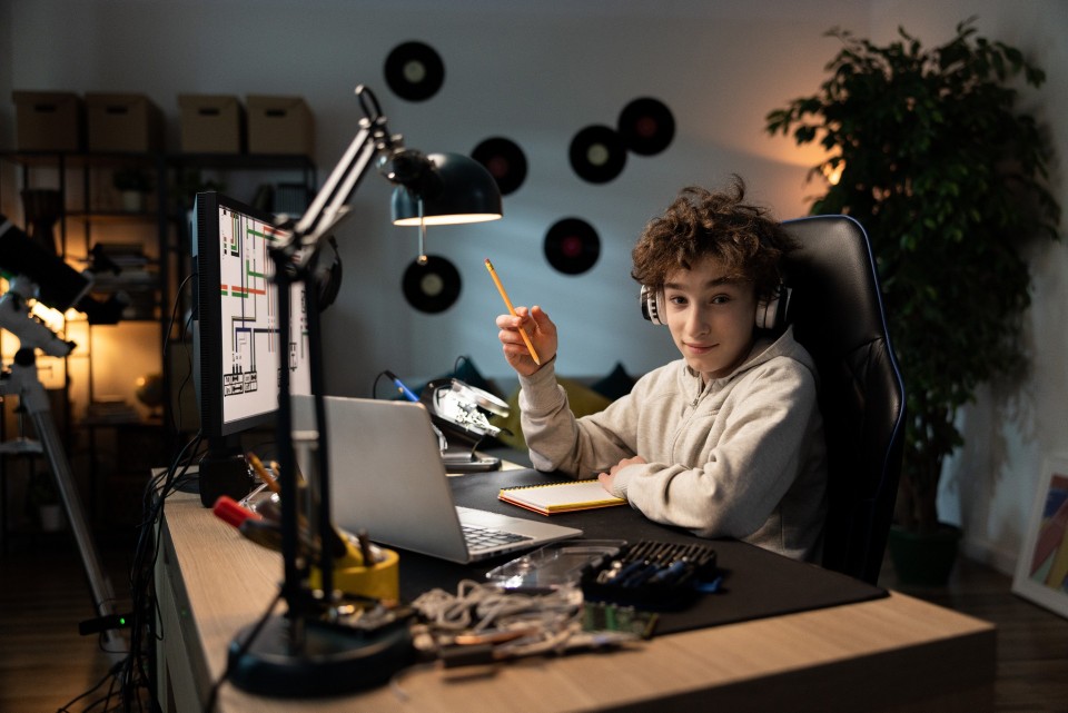Nastoletni chłopak uczący się przy dobrze oświetlonym biurku