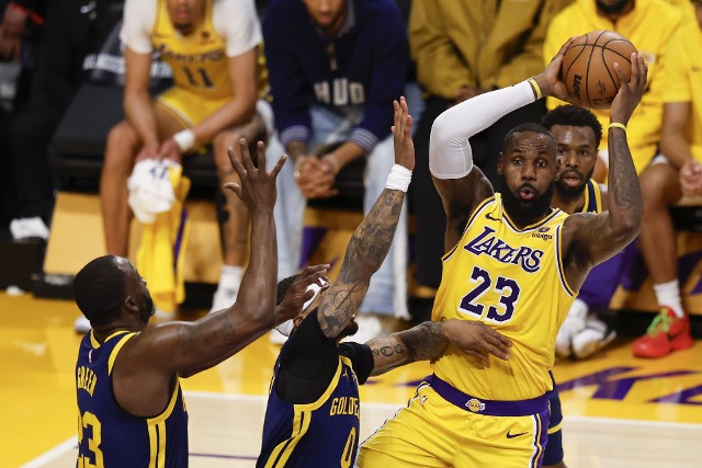 epa11268768 Los Angeles Lakers forward LeBron James (R) looks to pass the ball while being guarded by Golden State Warriors forward Draymond Green (L) and Golden State Warriors guard Gary Payton II (C) during the third quarter of the NBA basketball game between the Golden State Warriors and Los Angeles Lakers in Los Angeles, California, USA, 09 April 2024. EPA/CAROLINE BREHMAN SHUTTERSTOCK OUT Dostawca: PAP/EPA.