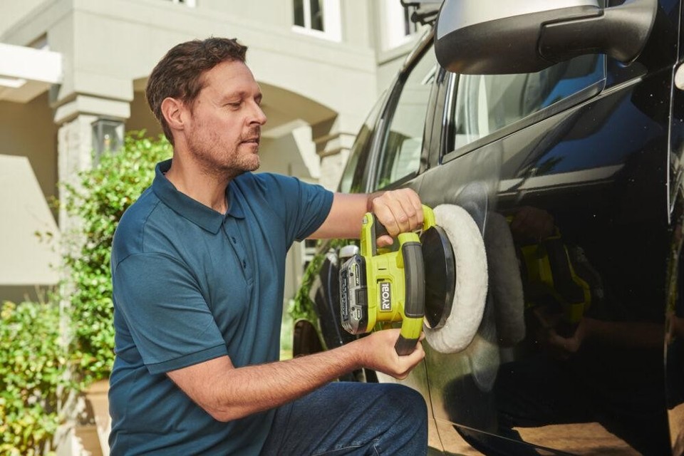 Mężczyzna poleruje lakier w samochodzie przy użyciu polerki akumulatorowej RYOBI
