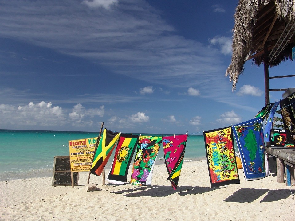 Jamajska plaża z rozwieszonymi ręcznikami w barwach narodowych.